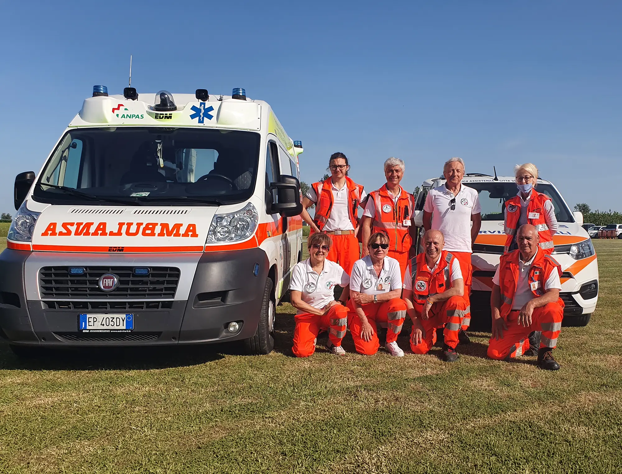 Ambulanza e squadra di volontari su prato verde